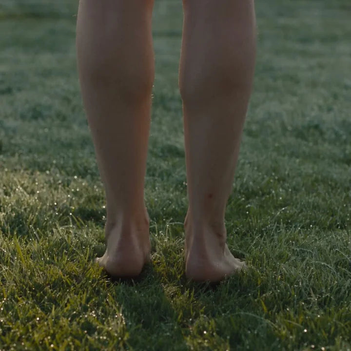 Bare feet in contact with grass outdoors